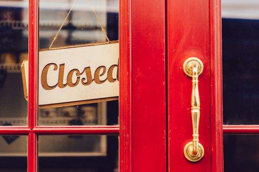 closed sign in the window of a red door