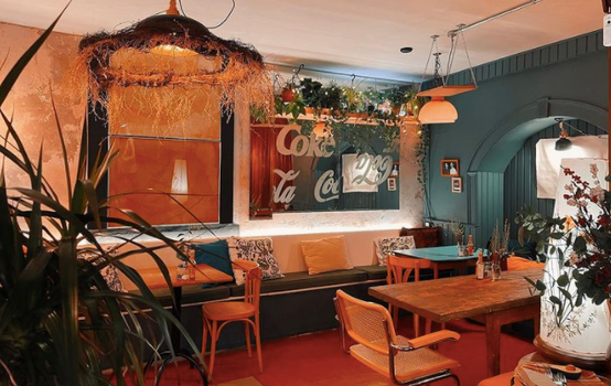 interior of a cafe with seats, colourful walls and plants