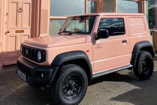 a pastel peach jeep parked outside The Fat Fox