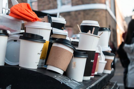 bin overflowing with used disposable coffee cups