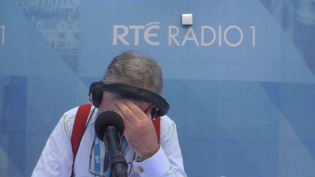 Joe Duffy on Liveline with his head in his hand, "RTE Radio 1" signage on the wall behind him