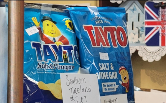two packets of salt and vinegar tayto, one with northern packaging, one with southern