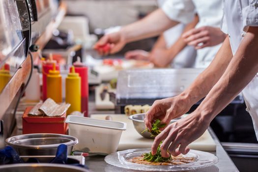 kitchen staff preparing food in restaurant kitchen