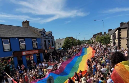 Huge rainbow flag being carried by a crows through the town of Buncrana for Donegal Pride