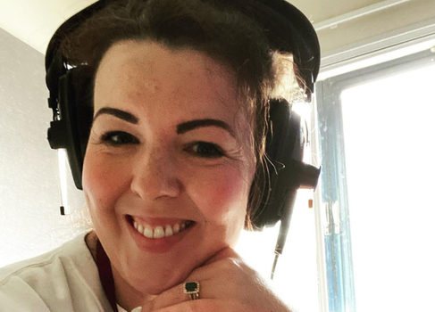 close up of Lisa McGee smiling and wearing radio headphones