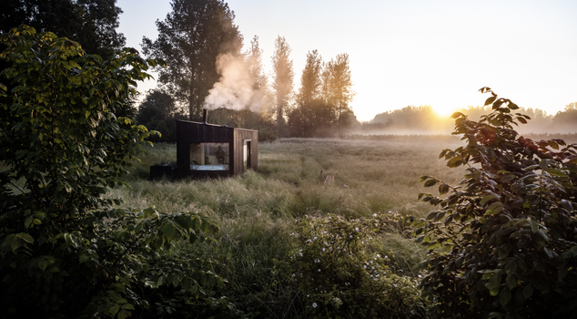 eco-style cabin in a field with trees in the background