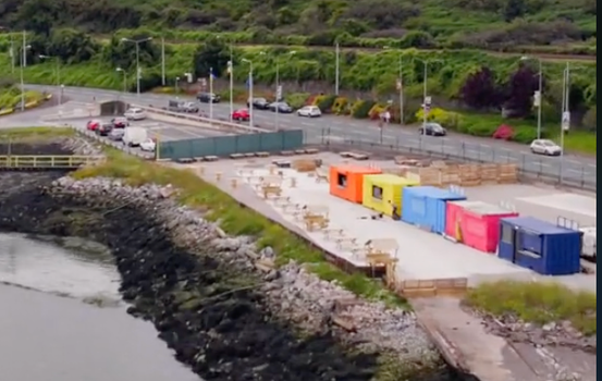 five colourful shipping containers side by side at boat yard food market in cobh