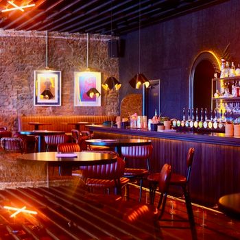 interior of goldies bar with candles, exposed brick wall, mirrors and artwork