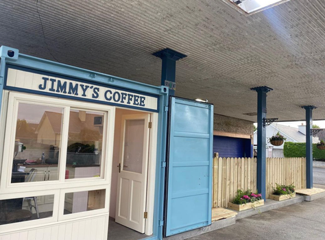blue shipping container cafe with a sign that reads Jimmy's Coffee