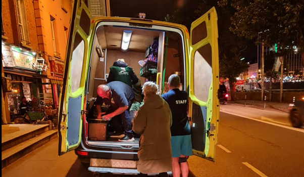 the back of an open van, filled with goods to be donated to homeless people
