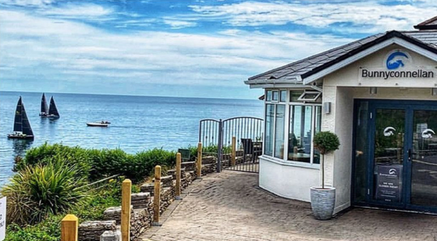 exterior of bunnyconnellan restaurant with sea view and blue skies in the background