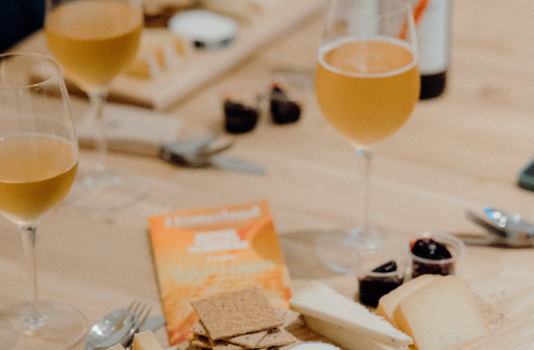 wine glasses and cheeseboard on a natural wood table