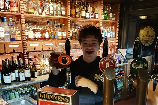stranger things actor Gaten Matarazzo pulling a pint of guinness in a kerry pub