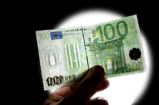 counterfeit euro note being held up against the light