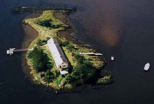 aerial shot of a private island with a long single storey property on it