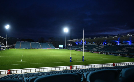 an empty rugby stadium at night with floodlights on